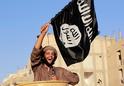 Miliziano dell'ISIS sventola la bandiera del Califfato islamico